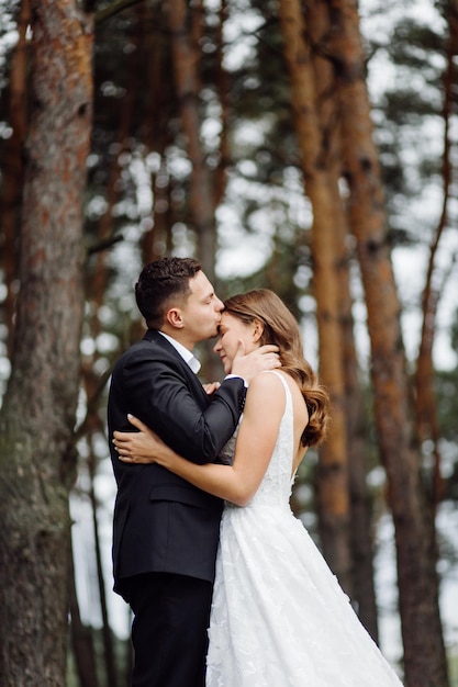 Os noivos correm por uma floresta Sessão de fotos de casamento