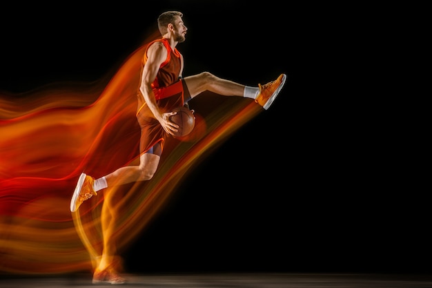 Os rastros de fogo. Jovem jogador de basquete caucasiano do time vermelho em ação