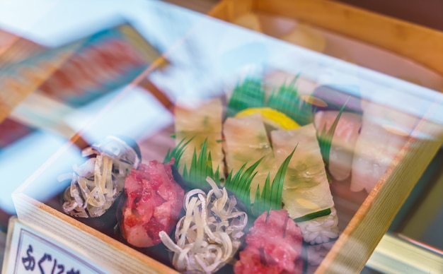 Os rolos do sushi de plástico em um caso de exibição
