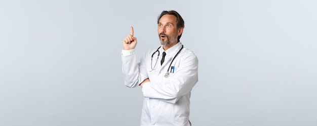 Os trabalhadores de saúde do surto de coronavírus covid e o conceito de pandemia excitaram o médico no jaleco branco feito ...