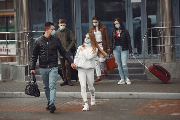 Os viajantes que saem do aeroporto estão usando máscaras de proteção