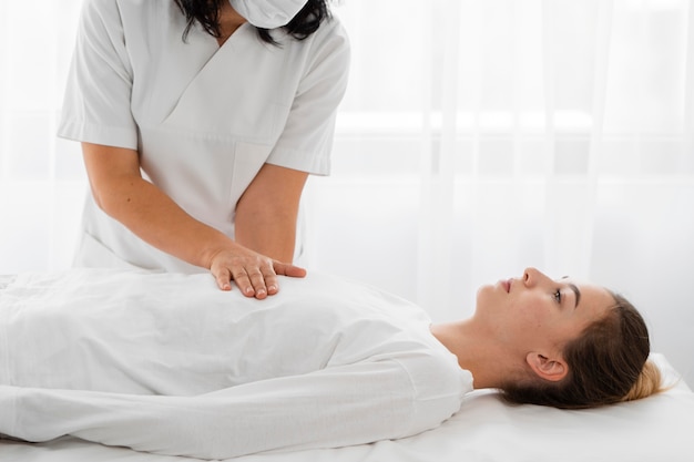 Osteopata tratando uma paciente massageando seu corpo