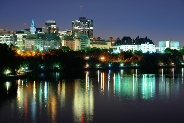 Ottawa à noite sobre o rio com arquitetura histórica.