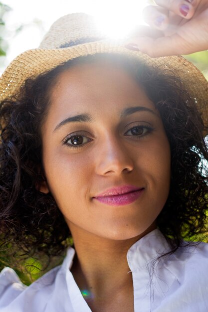 Outdoor Portrait of beautiful young woman posando com chapéu