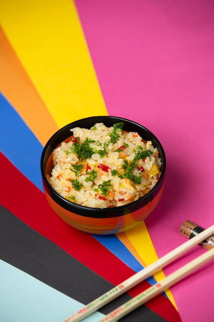 Ovo frito arroz com pimentão e endro em fundo colorido