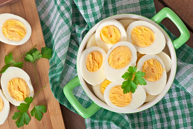 Ovos cozidos em uma tigela decorada com folhas de salsa