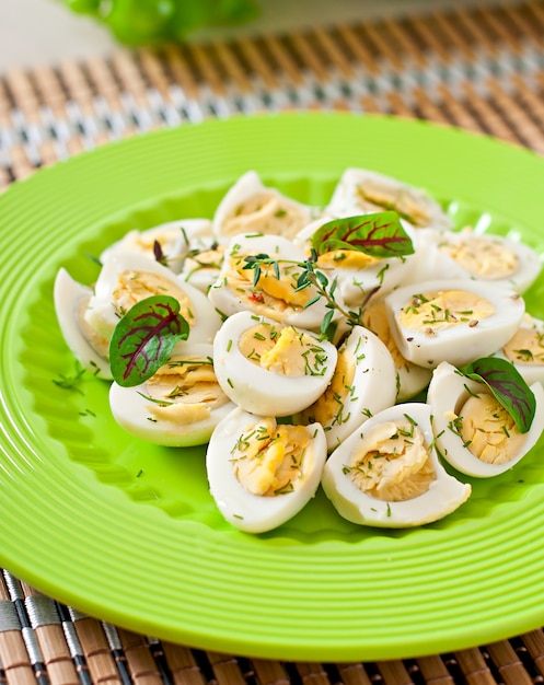 Foto grátis ovos de codorna cozidos ao meio em um prato verde