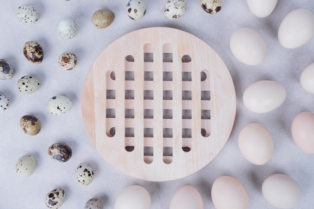 Ovos de codorna orgânicos e ovos de galinha na superfície branca.