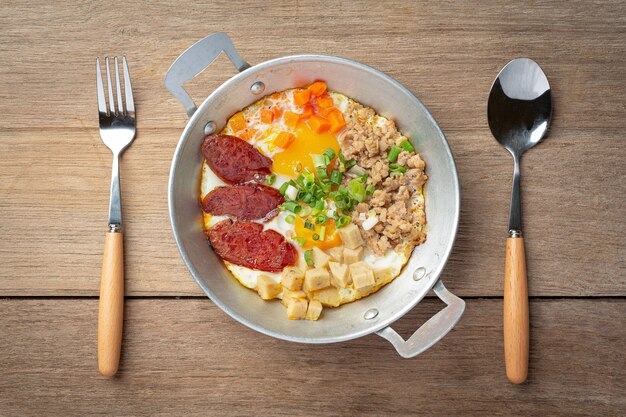 Ovos de panela polvilhados com salsicha chinesa, bacon em cubos, café da manhã.