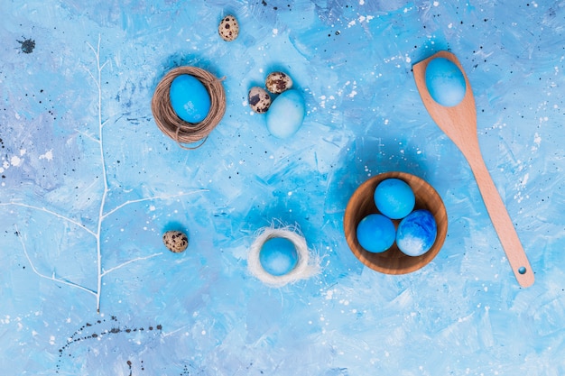 Foto grátis ovos de páscoa azuis em ninhos na mesa
