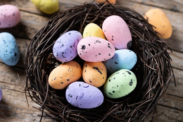 Ovos de Páscoa coloridos dentro de um ninho na mesa de madeira