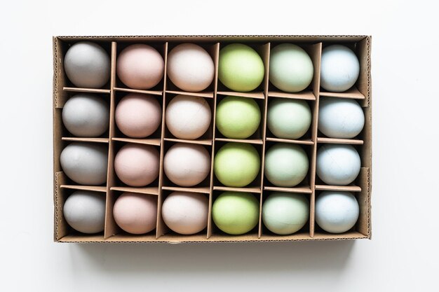 Ovos de páscoa coloridos em uma caixa em um fundo branco.
