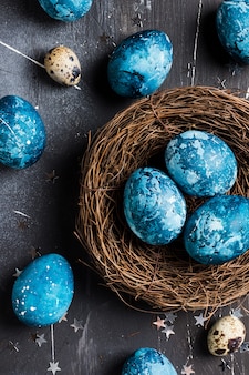 Ovos de páscoa no ninho pintado à mão em azul