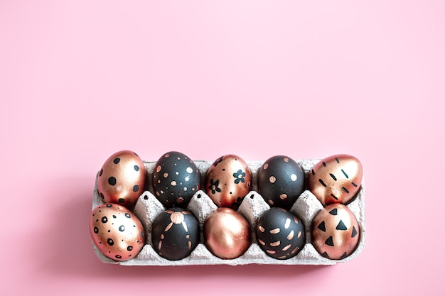 Ovos de Páscoa pintados festivos na parede rosa.