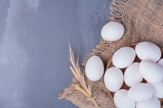 Ovos em uma bandeja de madeira em um pedaço de serapilheira