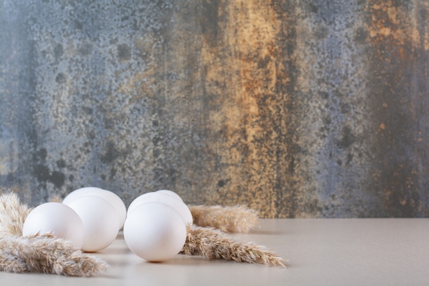 Foto grátis ovos frescos de galinha branca crus colocados na mesa bege.