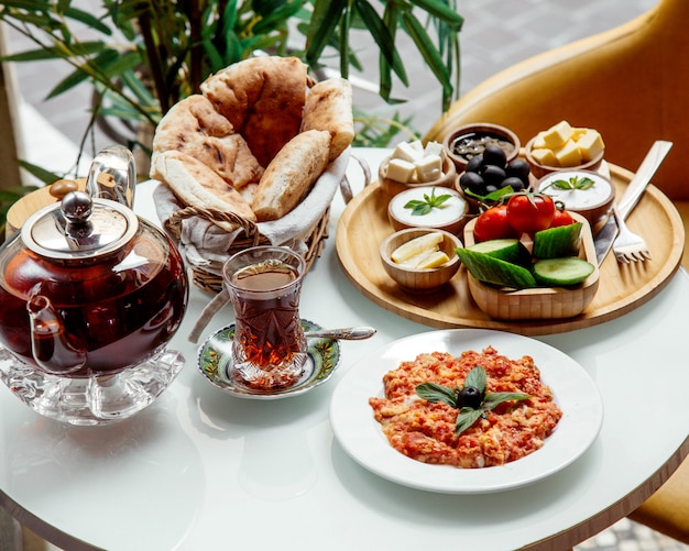 Ovos fritos com tomate e outros alimentos no café da manhã