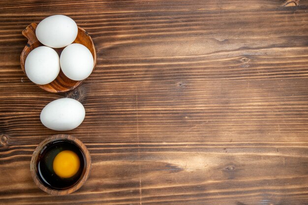 Ovos inteiros crus de vista superior sobre fundo de madeira marrom refeição comida café da manhã madeira ovo