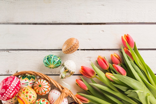 Foto grátis ovos na cesta perto de tulipas