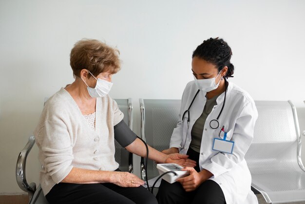 Paciente de tiro médio e médico com máscaras