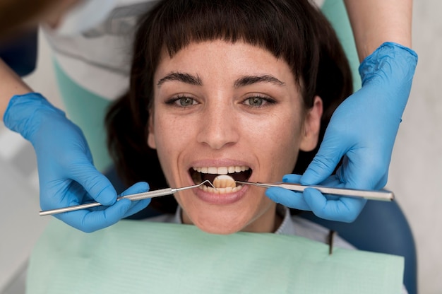 Paciente do sexo feminino fazendo procedimento no dentista