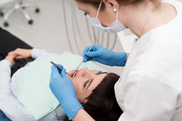 Paciente do sexo feminino fazendo procedimento no dentista