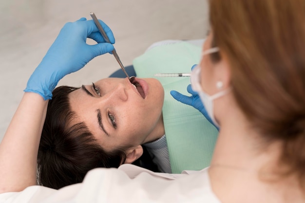 Paciente do sexo feminino fazendo procedimento no dentista