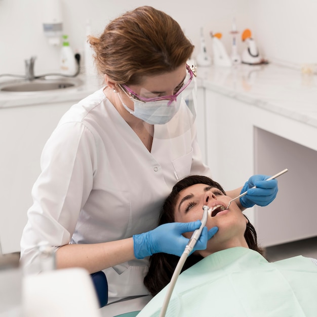 Foto grátis paciente do sexo feminino fazendo procedimento no dentista