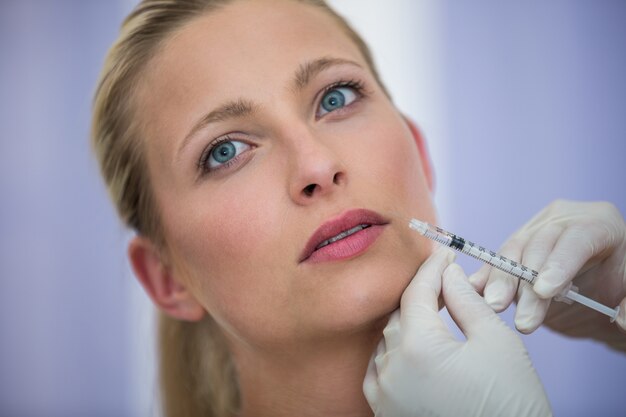Paciente do sexo feminino recebendo uma injeção de botox no rosto