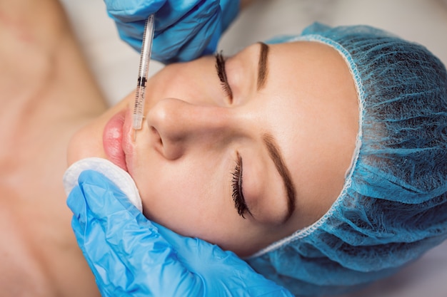 Paciente do sexo feminino recebendo uma injeção no rosto