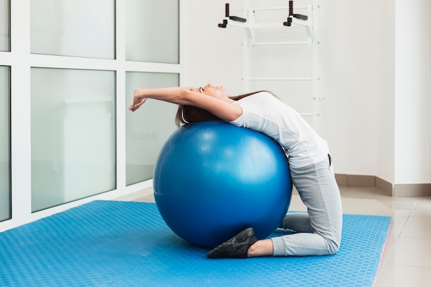 Paciente do sexo feminino usando bola de exercício