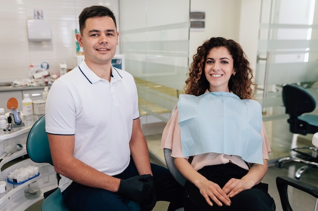 Paciente e dentista posando no escritório