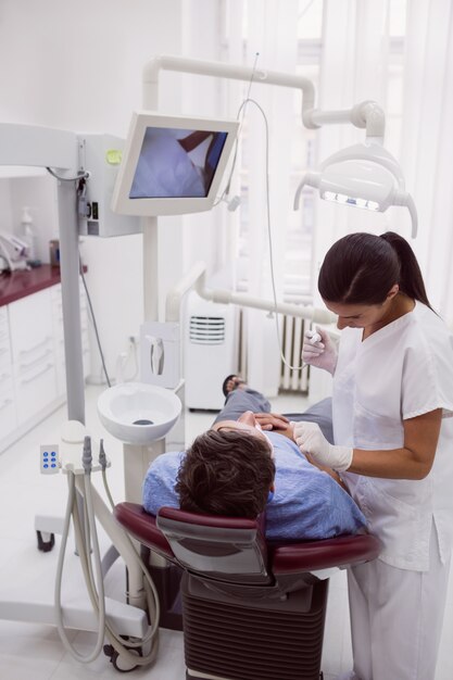 Paciente examinando dentista feminino