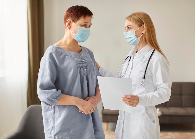 Foto grátis paciente idosa com máscara médica e médica cobiçada do centro de recuperação