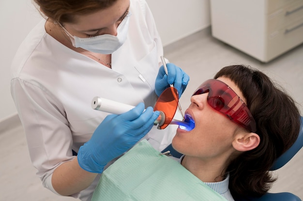 Paciente jovem fazendo procedimento odontológico no ortodontista