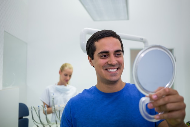 Foto grátis paciente verificando os dentes no espelho