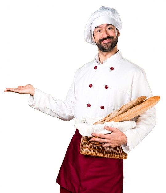 Padeiro jovem segurando um pouco de pão e apresentando algo