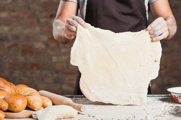 Foto grátis padeiro, segurando, achatado, massa, ligado, contador cozinha