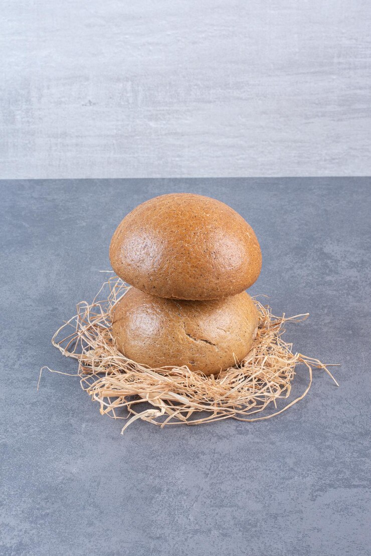 Foto grátis pães de hambúrguer empilhados em uma pilha de palha no fundo de mármore. foto de alta qualidade