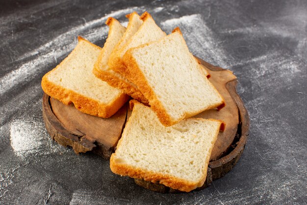 Pães de pão branco cortados em mesa de madeira