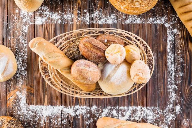 Pães no cesto dentro da moldura retangular feita com farinha