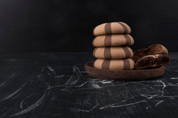 Pãezinhos de biscoito de cacau em uma pilha em uma bandeja de madeira