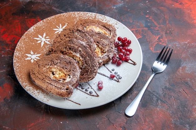 Pãezinhos de biscoito doce em fatias de bolos cremosos no chão escuro bolo de torta doce