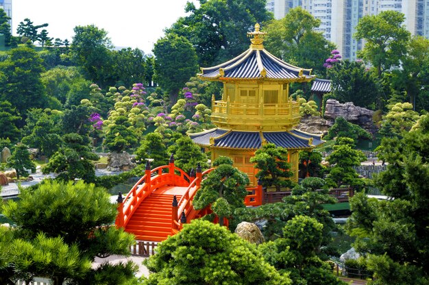 Pagode de ouro e ponte vermelha em jardins de Nan Lian, cidade de Kowloon, Hong Kong