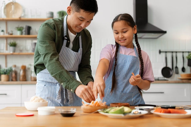 Pai a ensinar filho a fazer sushi.