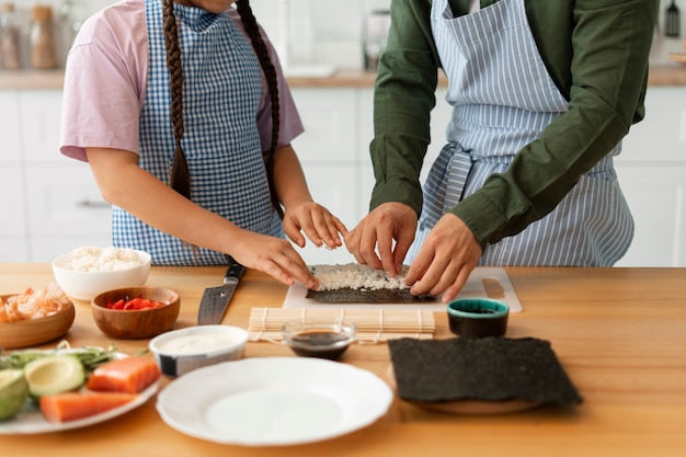 Pai a ensinar filho a fazer sushi.