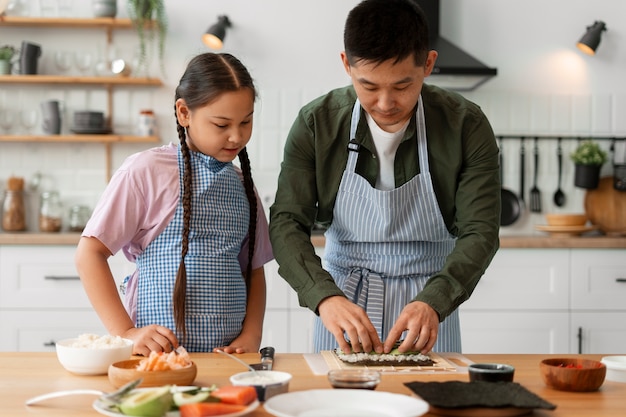 Pai a ensinar filho a fazer sushi.