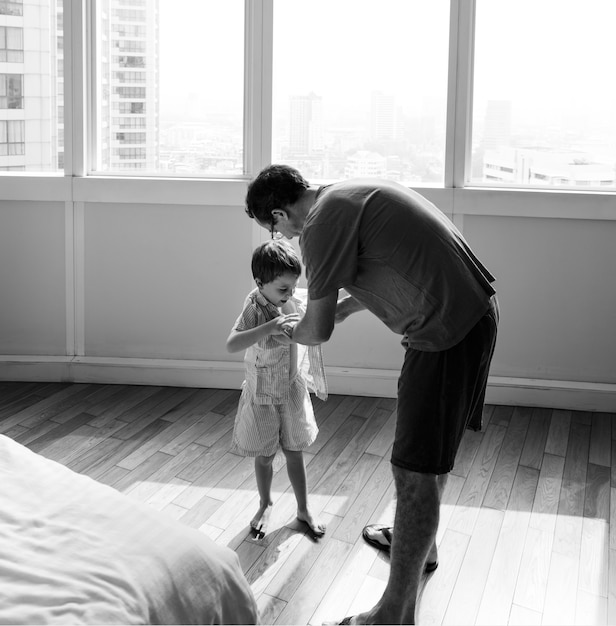 Foto grátis pai ajudando o filho a se vestir