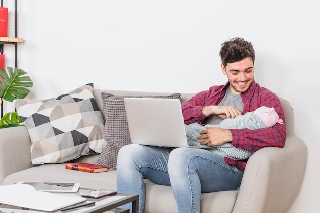 Foto grátis pai, com, bebê, usando computador portátil