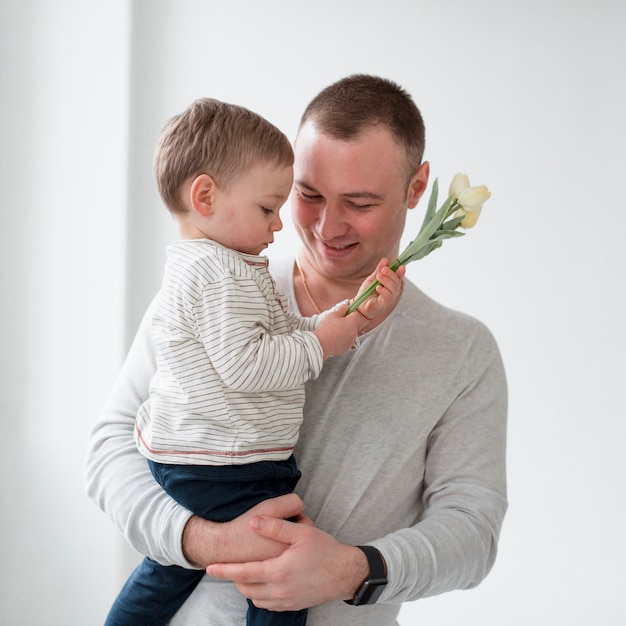 Foto grátis pai com criança segurando flor